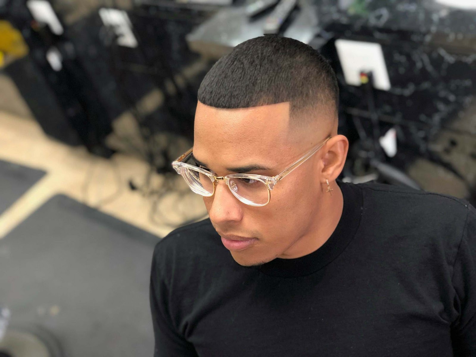 Bald fade with a crisp front lineup on a customer wearing clear glasses